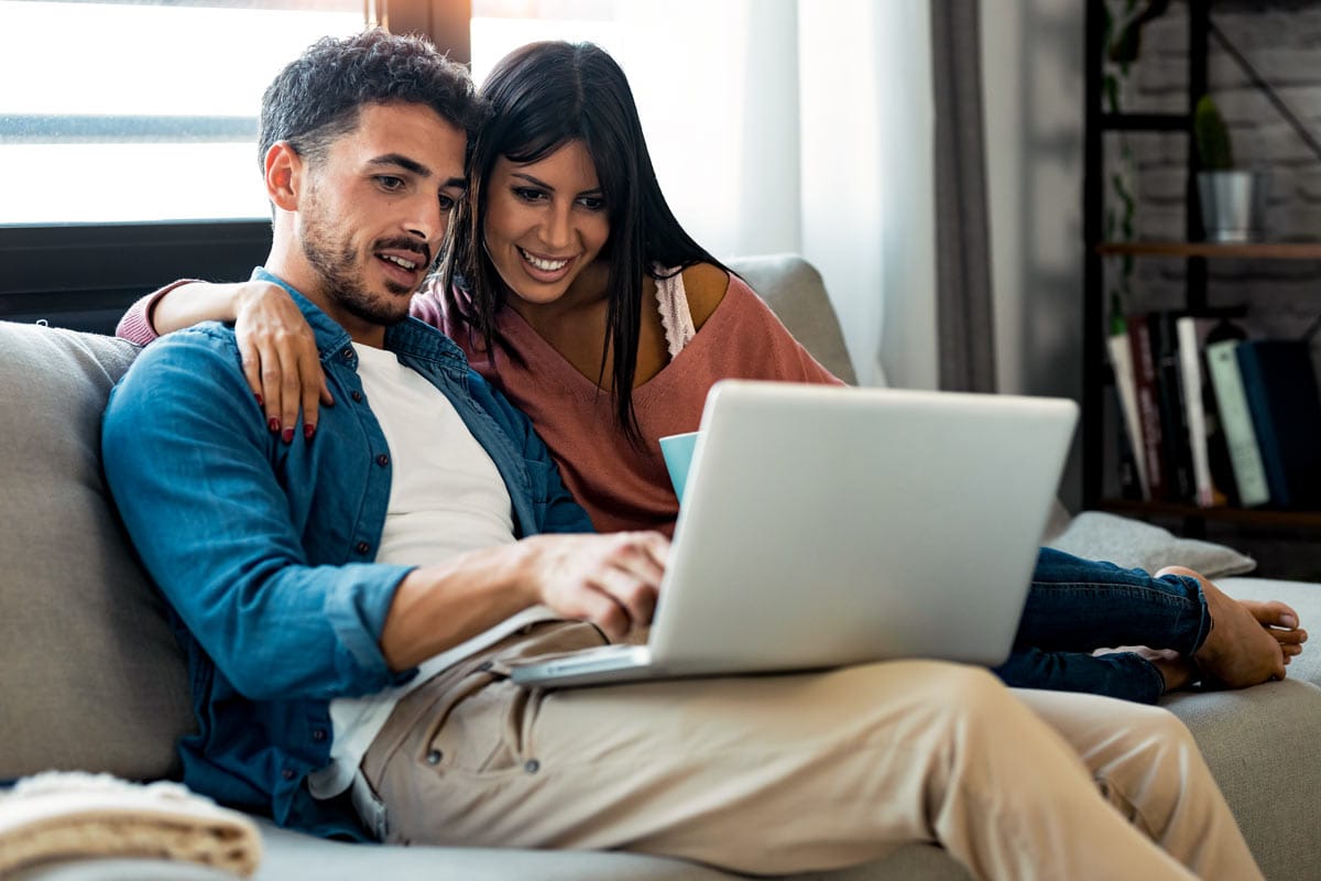 Couple using laptop in living room