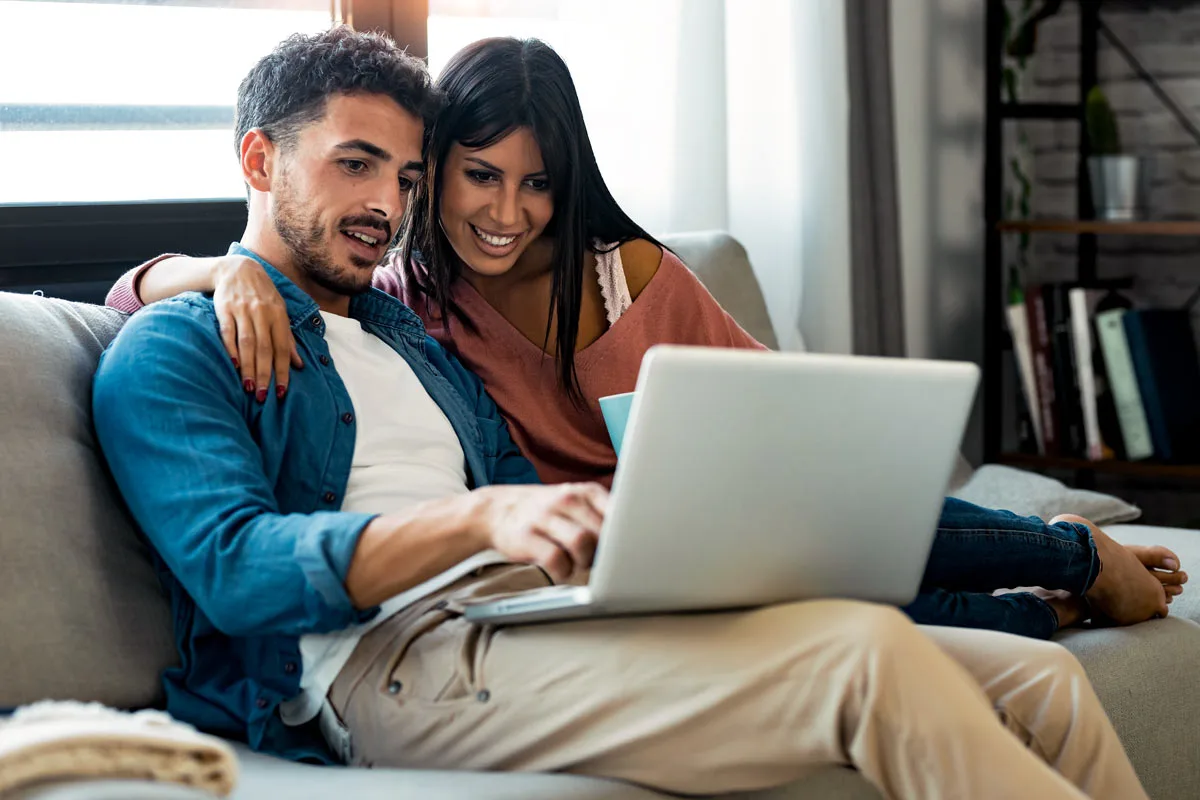 Couple using laptop in living room