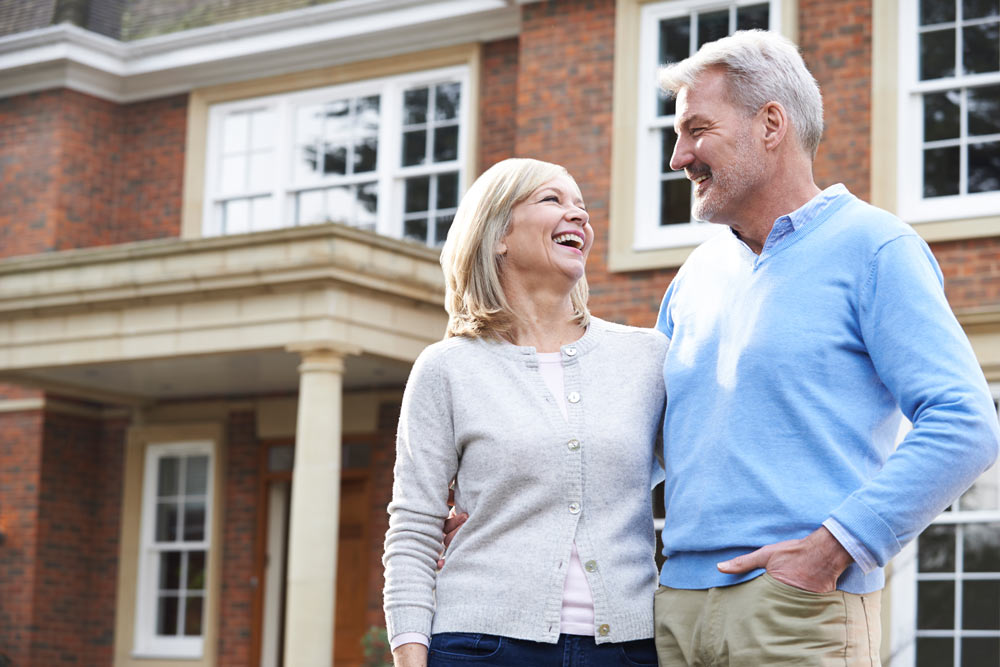 Middle aged couple outside house